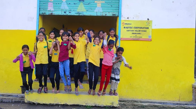 group of happy kids dressed in yellow room uniforms